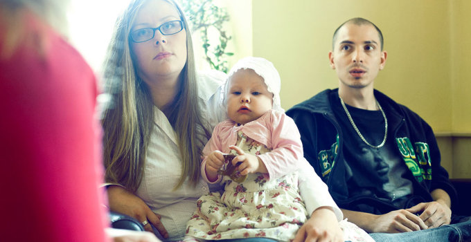 Junges Paar mit Baby in einem Beratungsgespräch.