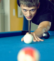 Jugendlicher spielt Billard