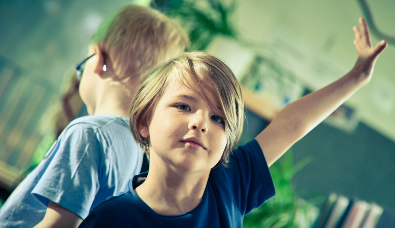 Szene im Kindergarten: Zwei Jungen machen Bewegungsspiele.